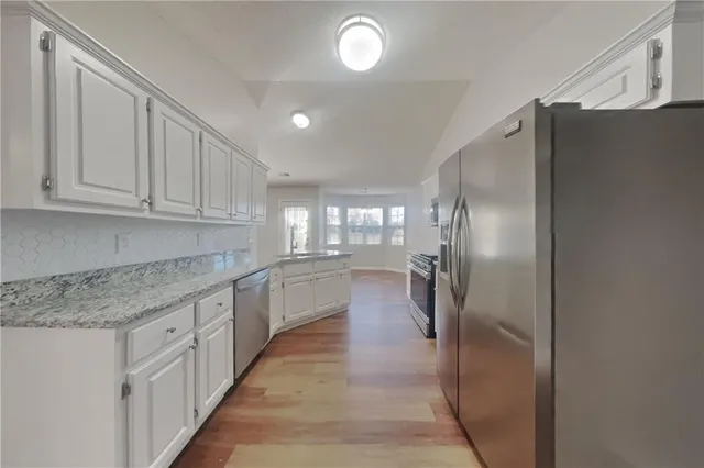 a large kitchen with cabinets and stainless steel appliances