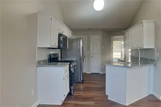 a kitchen with stainless steel appliances granite countertop a stove a sink and a refrigerator