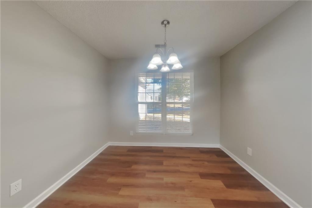 257 Ashland Park Court Southeast Lawrenceville, GA 30045 - Photo 8 of 21 a view of an empty room with wooden floor and a window