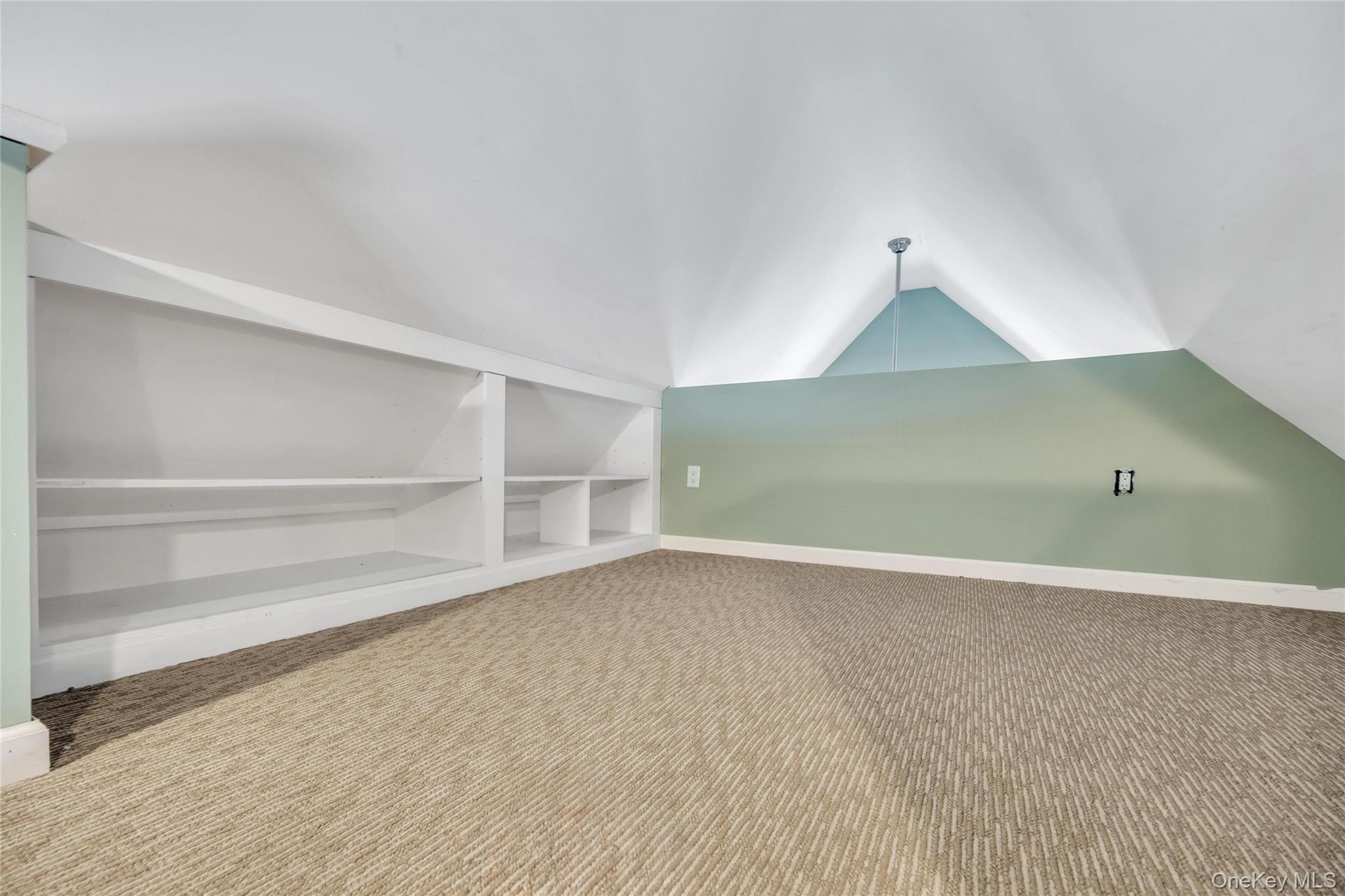 19 Joan Road Bay Shore, NY 11706 - Photo 33 of 50 Vaulted ceiling with a recessed light fixture, built-in shelving, low-pile patterned carpeting, and painted accent walls