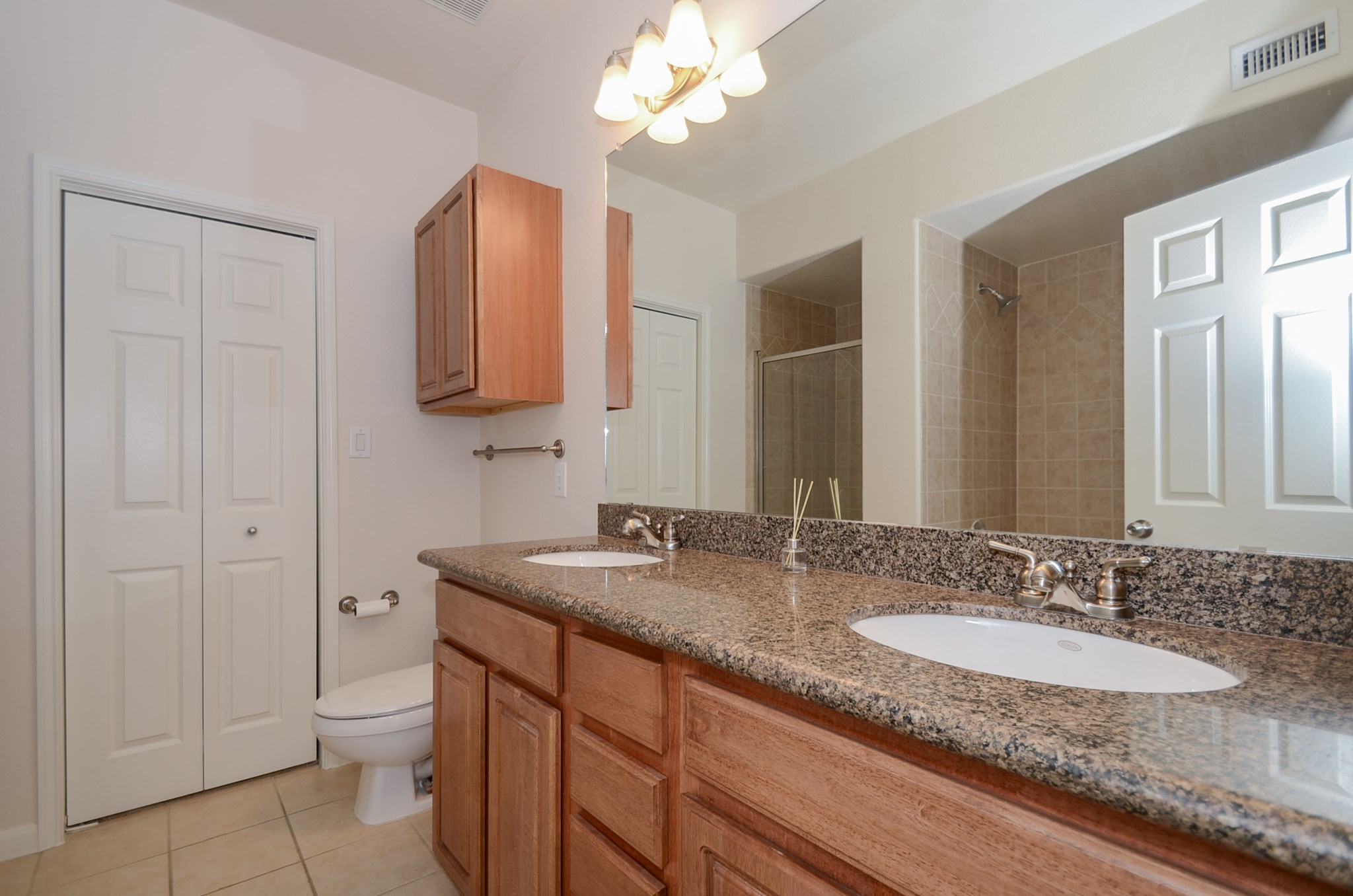 9200 Westheimer Road, Unit 802 Houston, TX 77063 - Photo 24 of 32 This primary restroom comes with a double sink vanity and wooden finish cabinets that complement the counter tops.