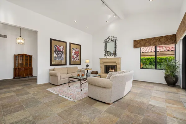 a living room with furniture large window and a fireplace