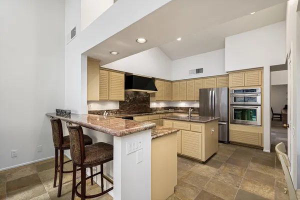 a kitchen with stainless steel appliances kitchen island granite countertop a sink and cabinets