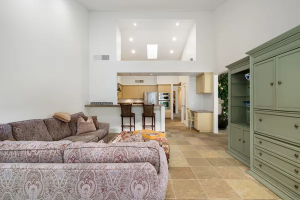 a living room with a couch and a view of kitchen