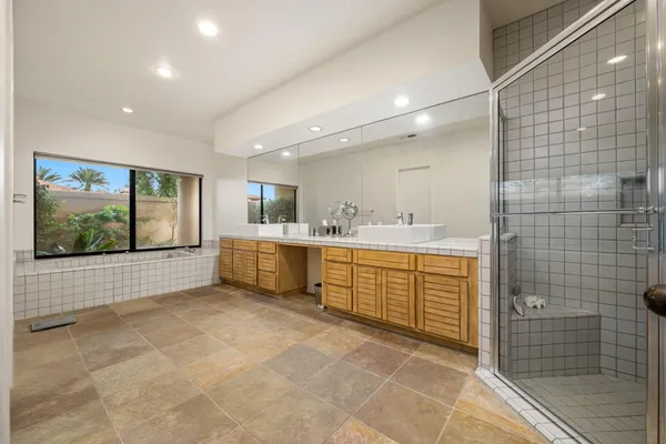 a large bathroom with a large mirror vanity and shower