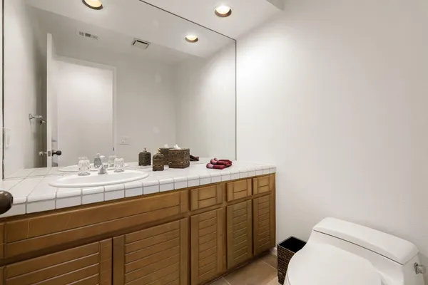 a bathroom with a sink vanity mirror and toilet