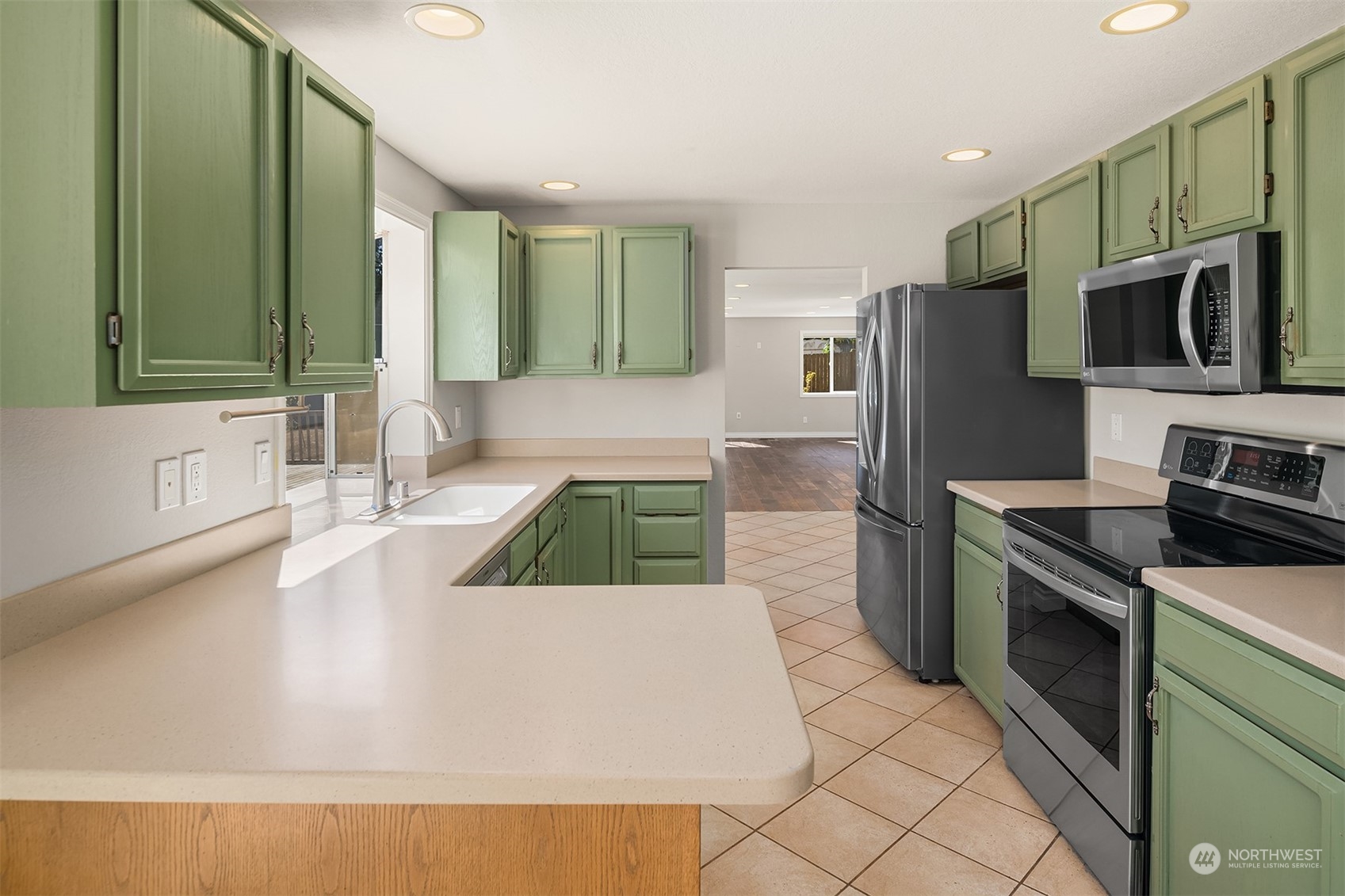 23333 45th Avenue Southeast Bothell, WA 98021 - Photo 13 of 36 a kitchen with stainless steel appliances granite countertop a sink and a stove top oven with wooden floor
