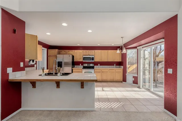 a kitchen with kitchen island stainless steel appliances a sink and counter space