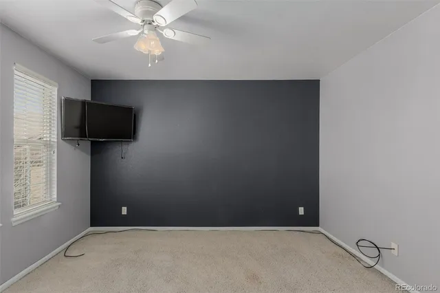 en empty room with windows and ceiling fan