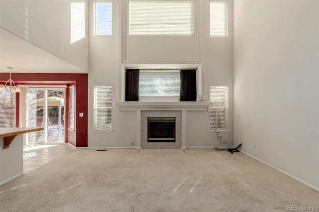 an empty room with fireplace and windows
