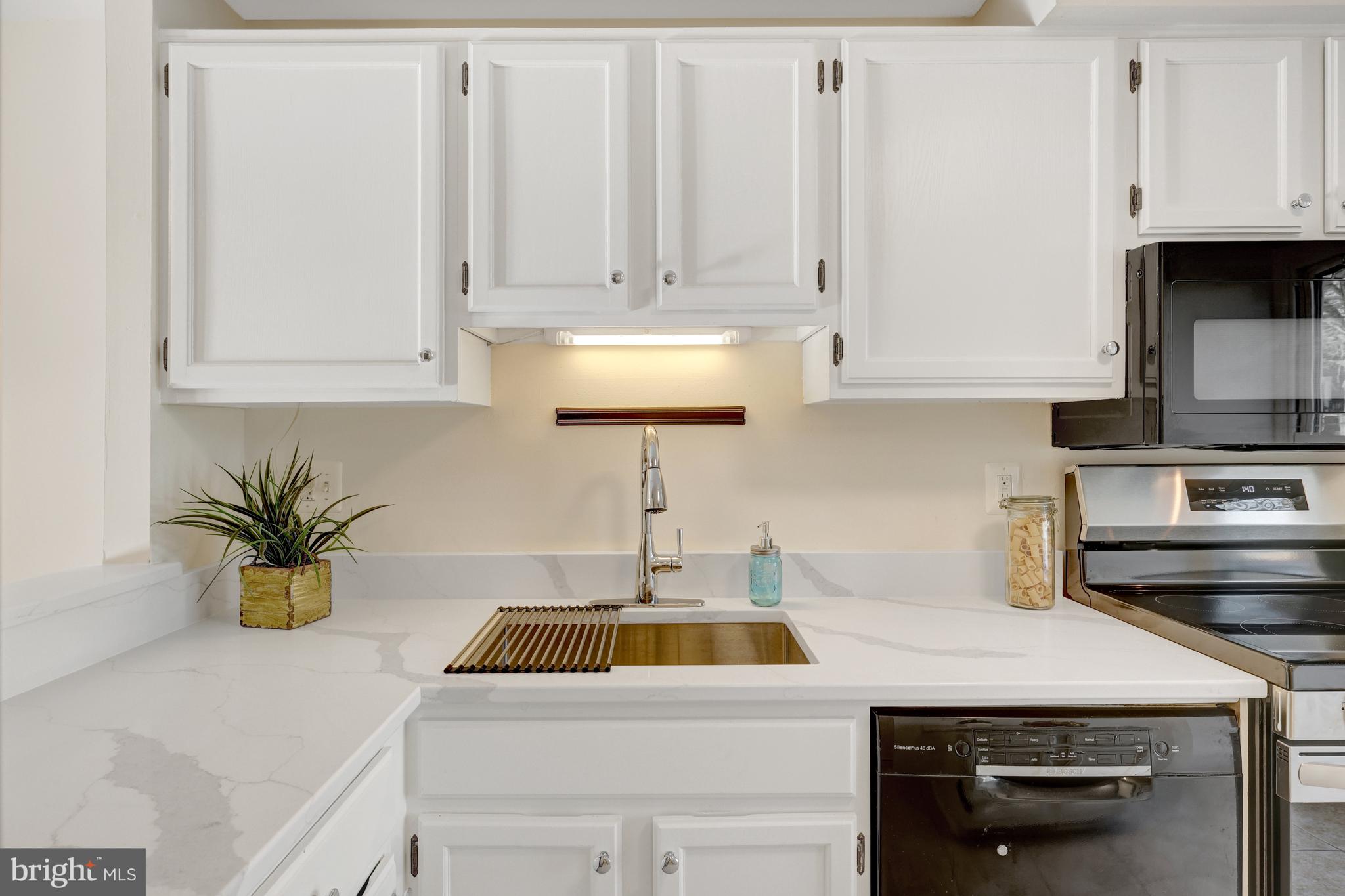 11200 Silentwood Lane Reston, VA 20191 - Photo 12 of 46 a kitchen with stainless steel appliances granite countertop a sink a stove and white cabinets