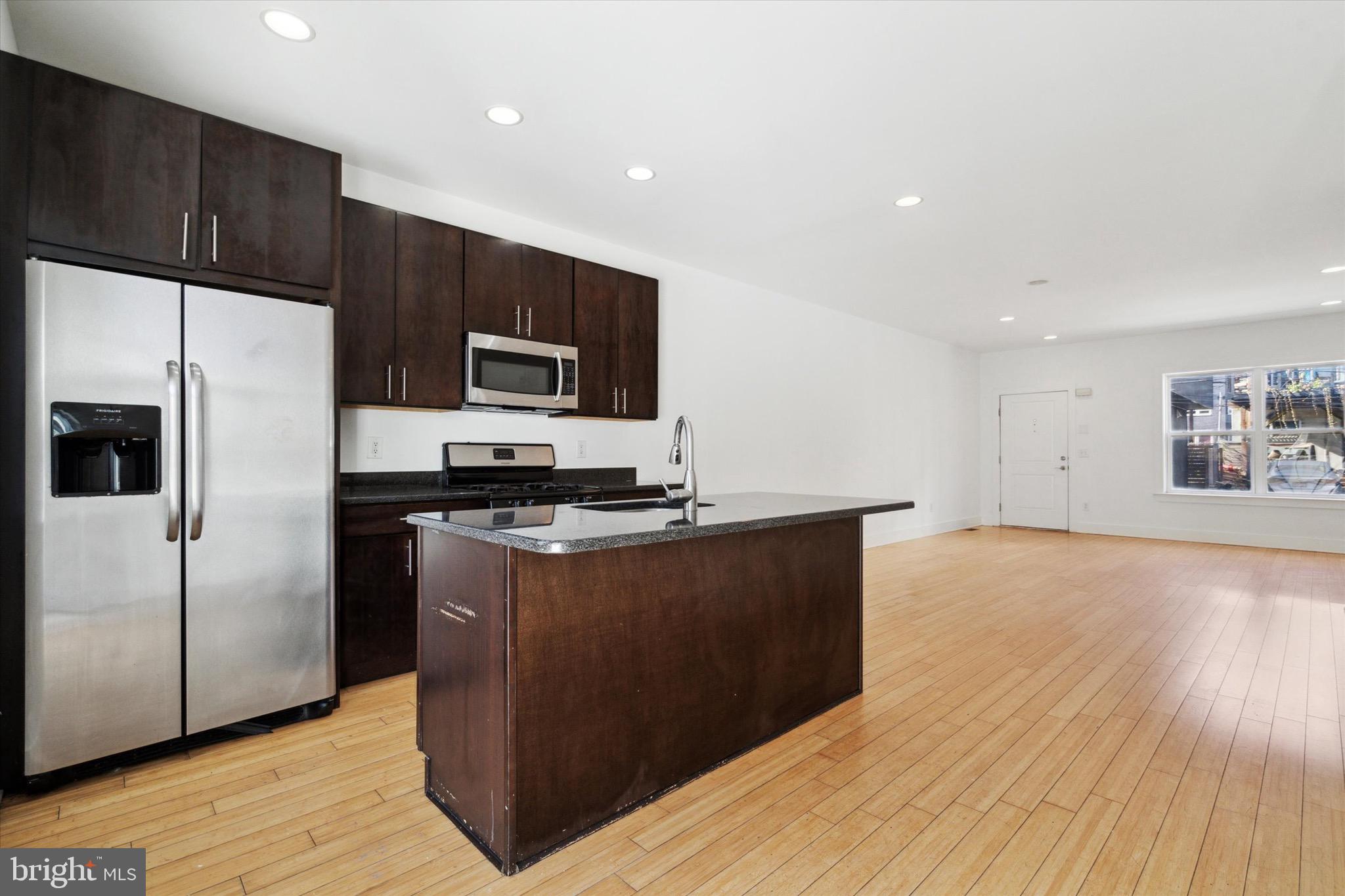 1345 Palethorp Street Philadelphia, PA 19122 - Photo 7 of 15 a kitchen with stainless steel appliances granite countertop a wooden cabinets a stove a sink and a refrigerator