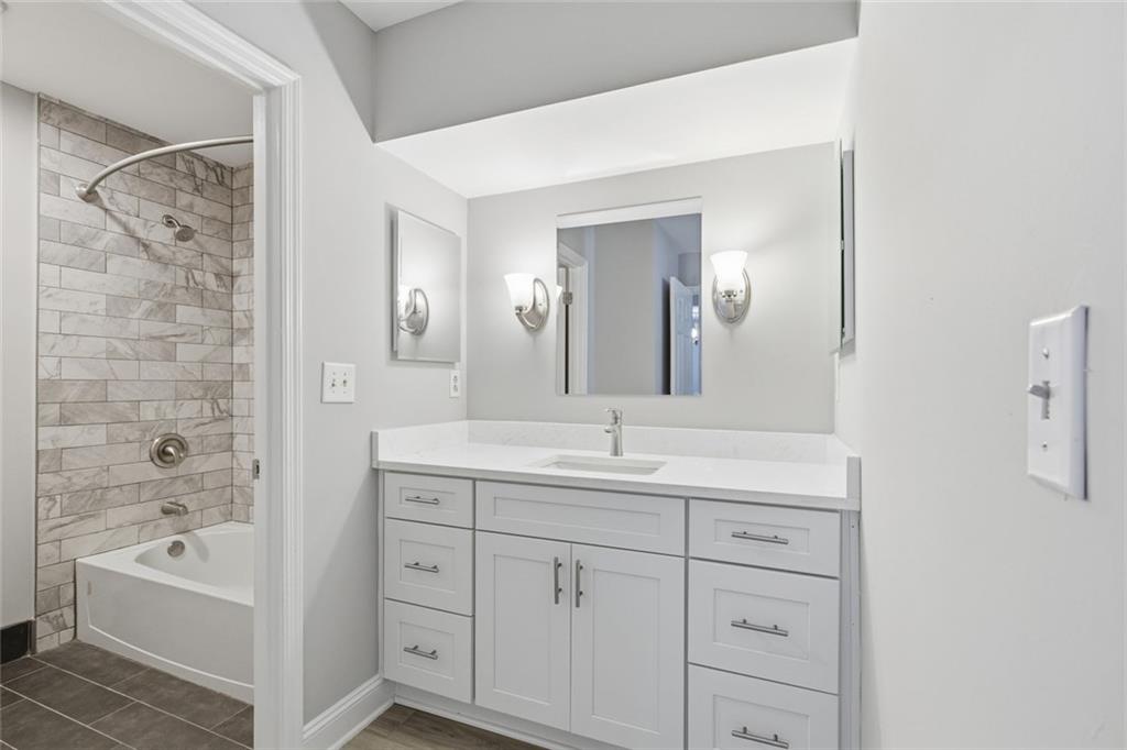 210 Appleby Drive, Unit 119 Athens, GA 30605 - Photo 21 of 35 a en suite bathroom with a double vanity sink a mirror and a bathtub