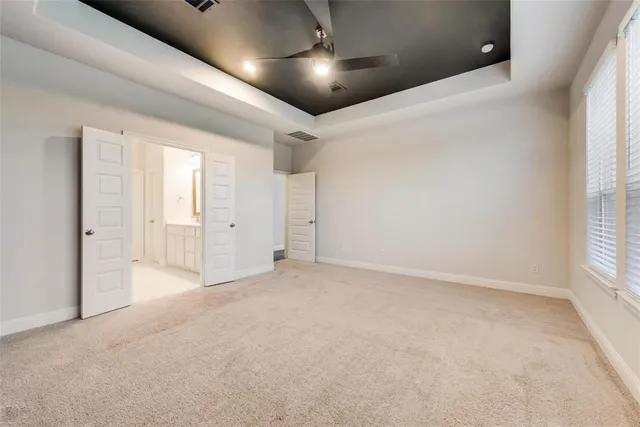 en empty room with windows and ceiling fan