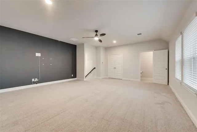 an empty room with a ceiling fan and window