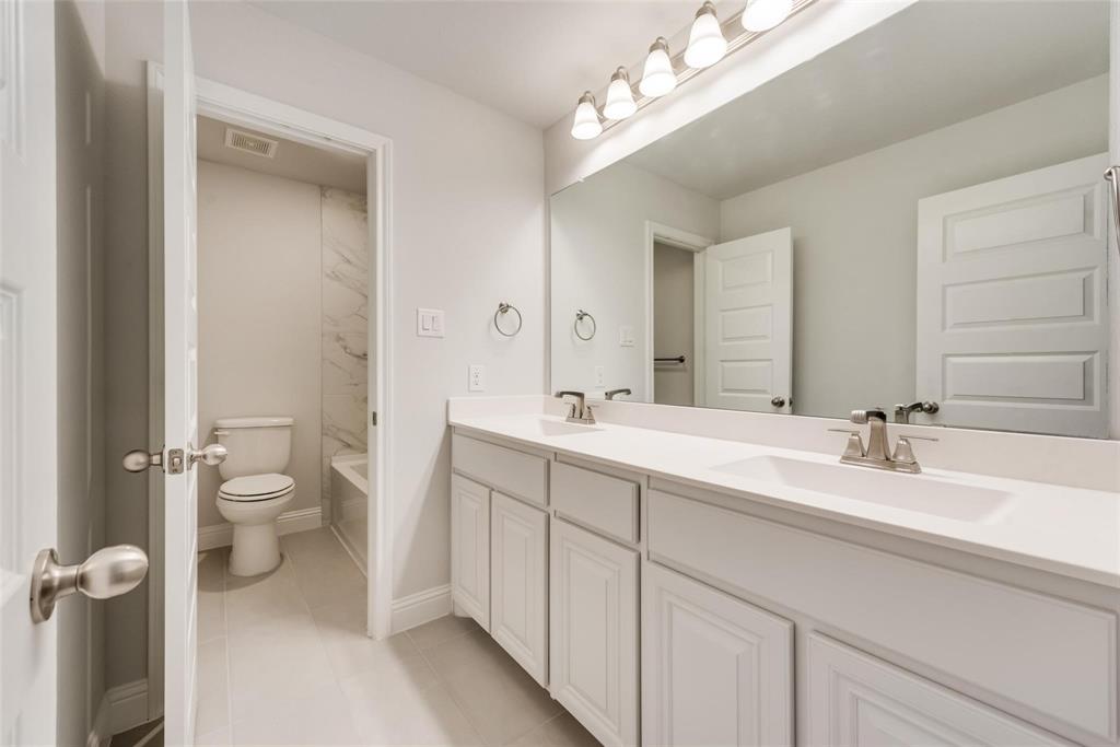 14623 Prairie Fire Drive Frisco, TX 75033 - Photo 23 of 36 a bathroom with a double vanity sink toilet and a mirror
