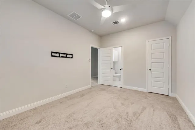 an empty room with closet and windows