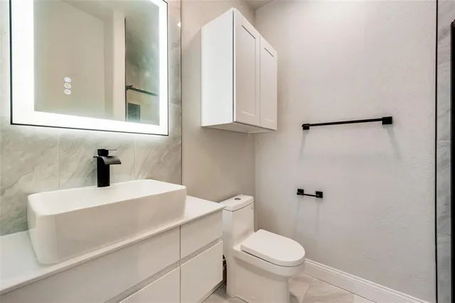 a bathroom with a sink a toilet and a mirror