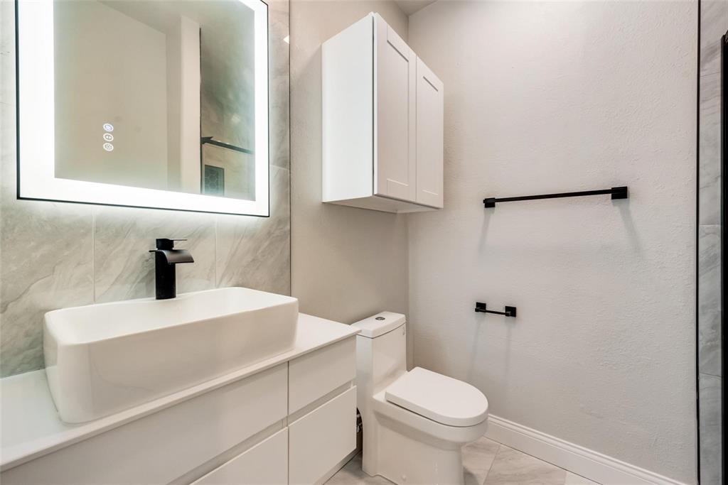 14623 Prairie Fire Drive Frisco, TX 75033 - Photo 28 of 36 a bathroom with a sink a toilet and a mirror