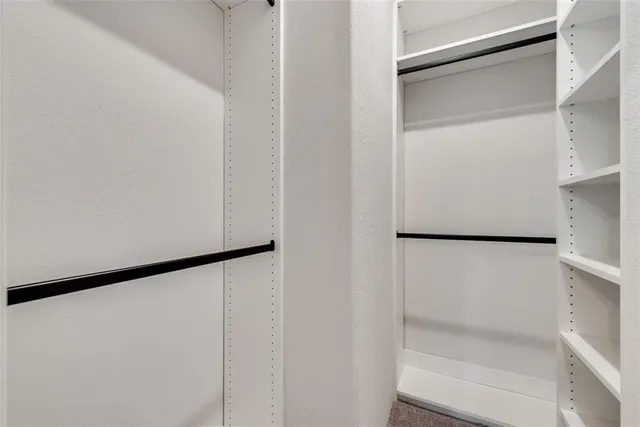 a view of walk in closet with empty racks