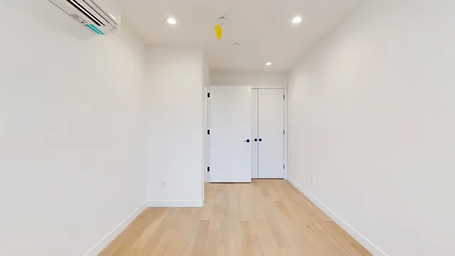 a view of empty room with wooden floor