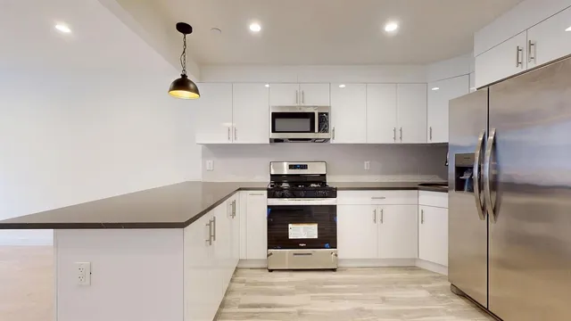 a kitchen with stainless steel appliances granite countertop a sink a stove and a refrigerator