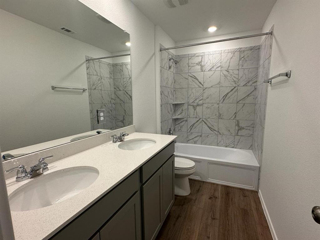 346 Carmello Kyle, TX 78640 - Photo 10 of 39 Full bath with double vanity, bathing tub / shower combination, dark wood finished floors, and recessed lighting