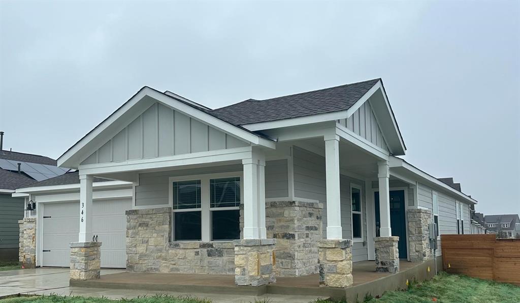 346 Carmello Kyle, TX 78640 - Photo 3 of 39 View of property exterior with board and batten siding, covered porch, a shingled roof, stone siding, and a garage