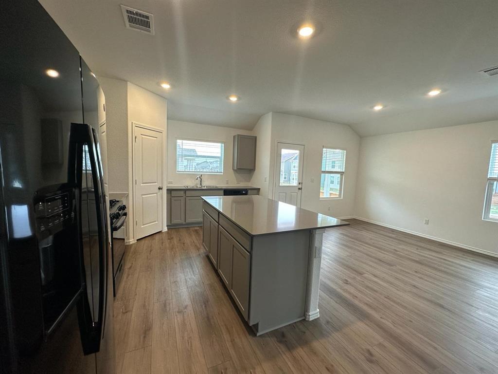 346 Carmello Kyle, TX 78640 - Photo 8 of 39 Kitchen with black appliances, gray cabinetry, a kitchen island, dark wood-style floors, and recessed lighting
