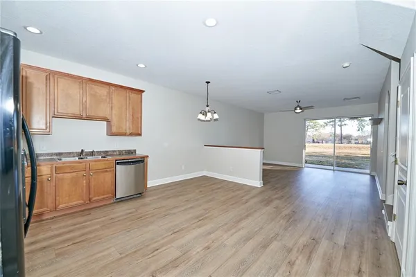 an empty room with wooden floor and ceiling fan