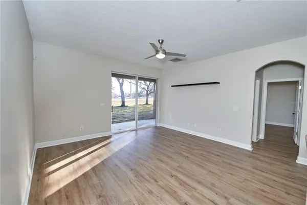 a view of empty room with wooden floor and window