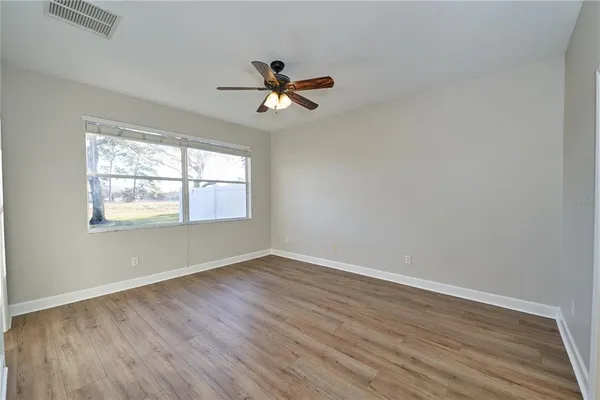 a spacious bathroom with a granite countertop toilet a sink and a mirror