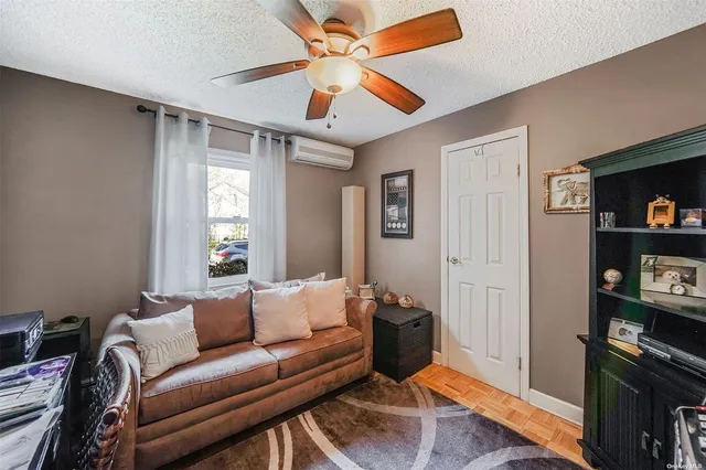 a living room with furniture a ceiling fan and a window