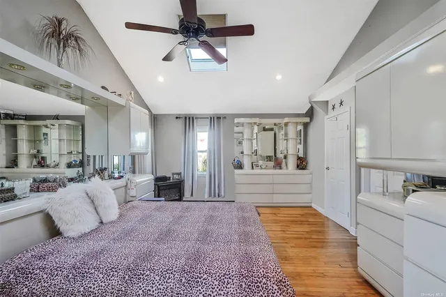 a large bedroom with a large bed a chandelier and closet