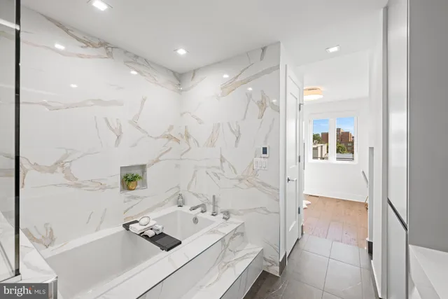 a bathroom with a bathtub sink and mirror