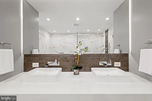 a bathroom with a sink a large mirror and vanity