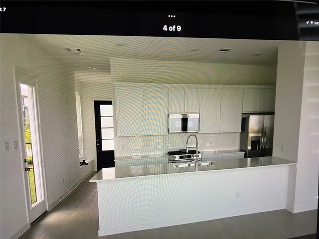 a large white kitchen with kitchen island
