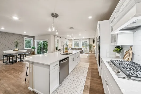 a large kitchen with kitchen island a large counter space a sink appliances and cabinets