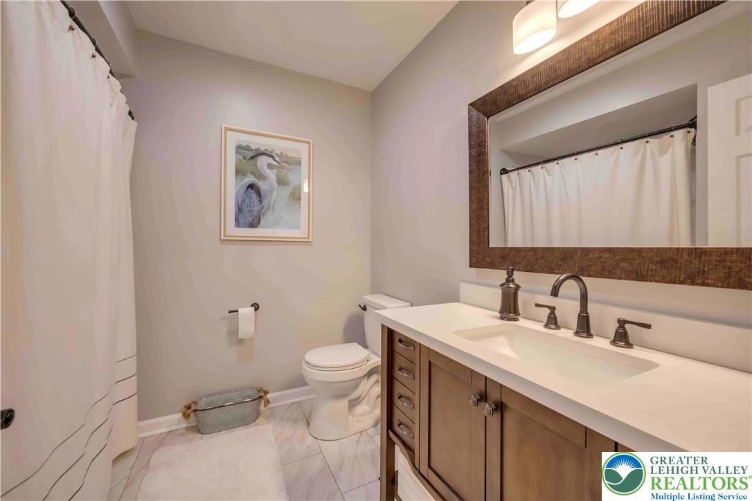 2448 Keeler Road Bath, PA 18014 - Photo 21 of 37 A well-appointed bathroom features a contemporary vanity, elegant mirror, and tiled flooring, perfect for daily routines.