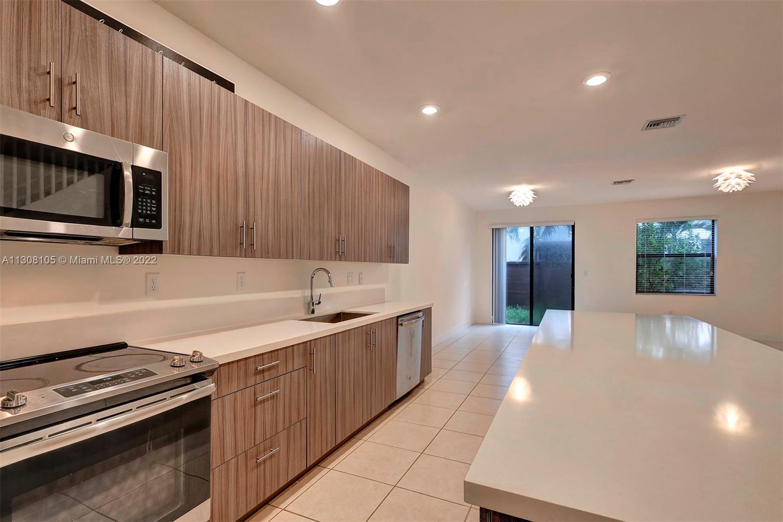 a kitchen with stainless steel appliances a sink dishwasher a stove microwave and cabinets