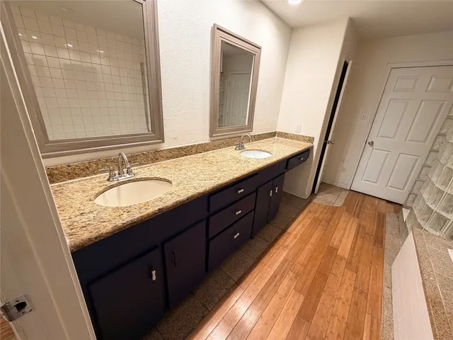 a spacious bathroom with a granite countertop sink and a mirror