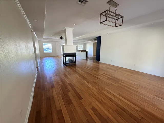 a view of empty room with wooden floor
