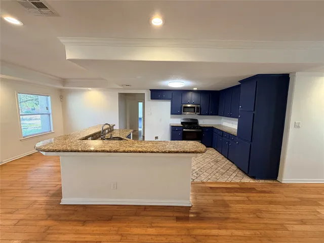 a view with kitchen island a sink wooden floor and a refrigerator