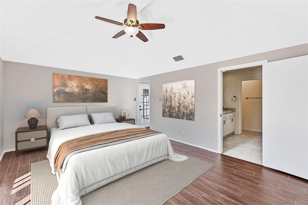 710 Cimarron Trail Irving, TX 75063 - Photo 11 of 39 a bedroom with a large bed and a chandelier