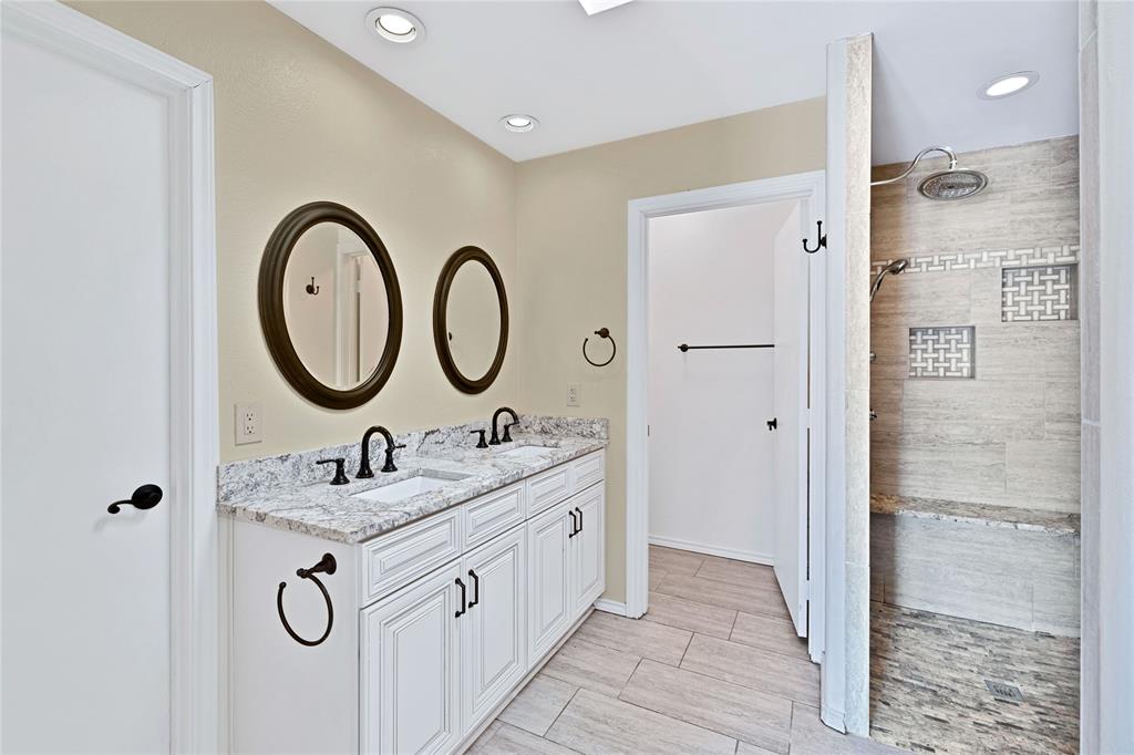 710 Cimarron Trail Irving, TX 75063 - Photo 14 of 39 a bathroom with a double vanity sink mirror and shower