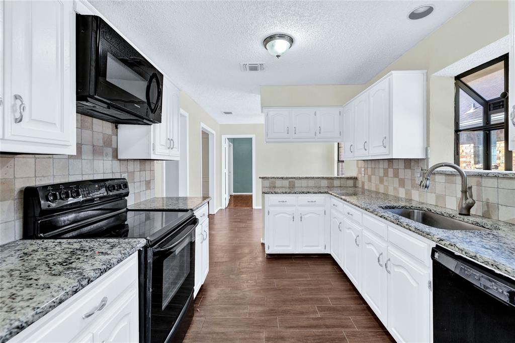 710 Cimarron Trail Irving, TX 75063 - Photo 19 of 39 a kitchen with stainless steel appliances granite countertop a sink stove microwave and cabinets