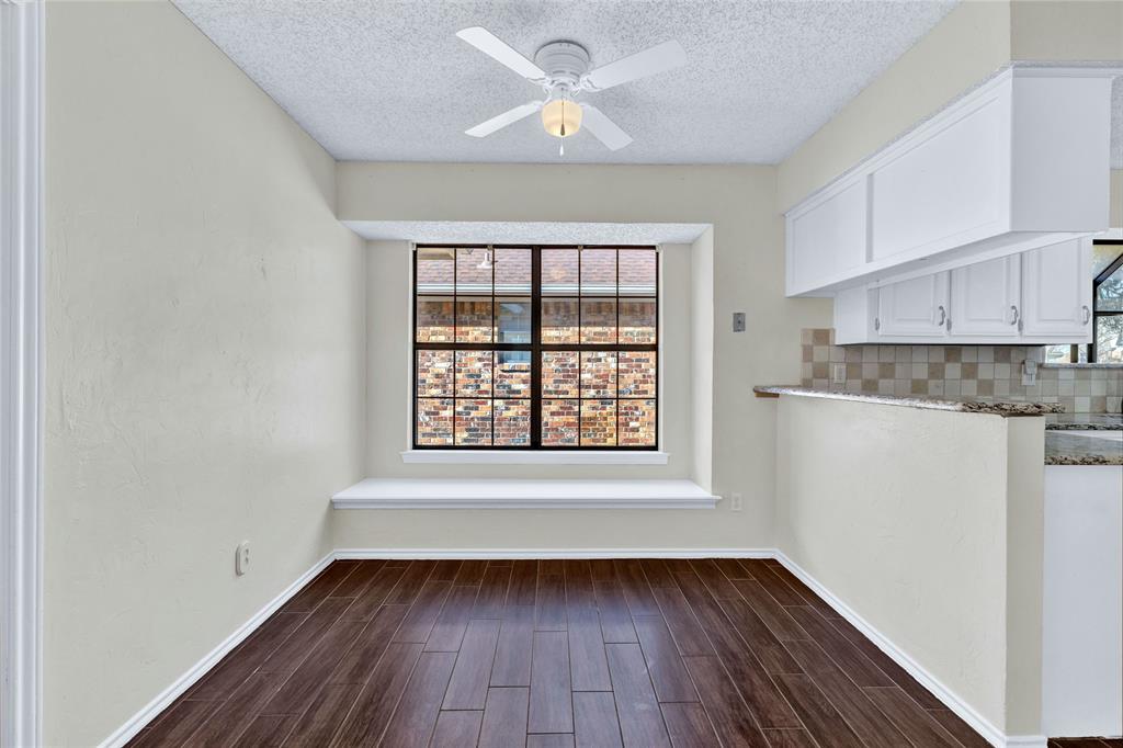 710 Cimarron Trail Irving, TX 75063 - Photo 20 of 39 a view of an empty room with window and wooden floor