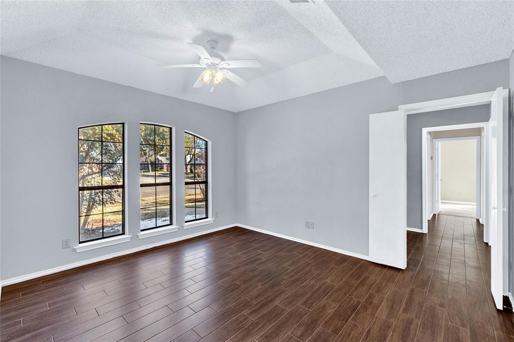 710 Cimarron Trail Irving, TX 75063 - Photo 24 of 39 a view of an empty room with wooden floor and a window