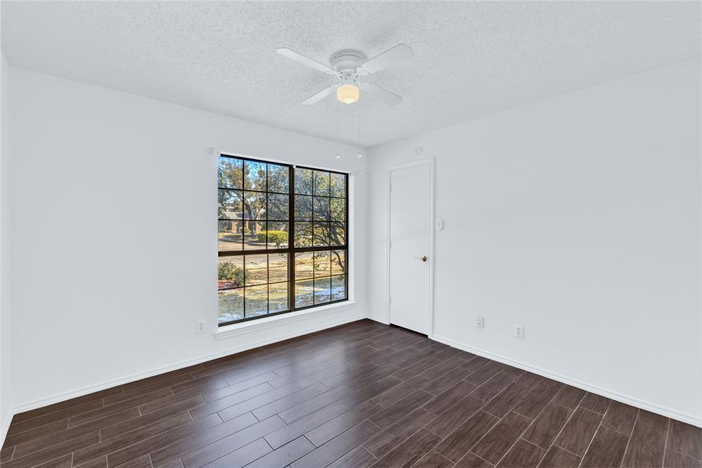 710 Cimarron Trail Irving, TX 75063 - Photo 28 of 39 an empty room with wooden floor and windows