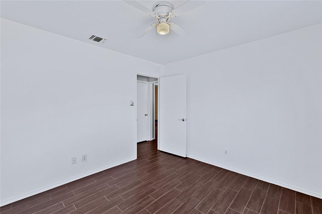 710 Cimarron Trail Irving, TX 75063 - Photo 29 of 39 a view of an empty room with wooden floor and fan